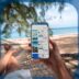 A Person Holding Their Phone While Lying In A Hammock On The Beach.jpg